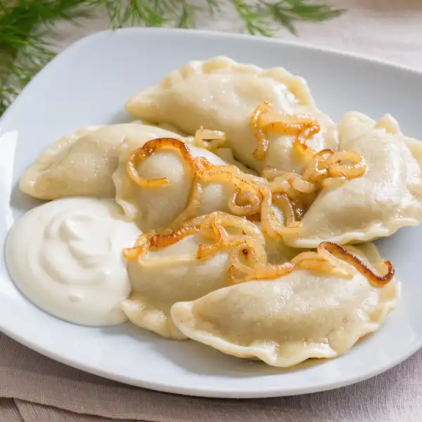 Pierogi dumplings with onions and sour cream