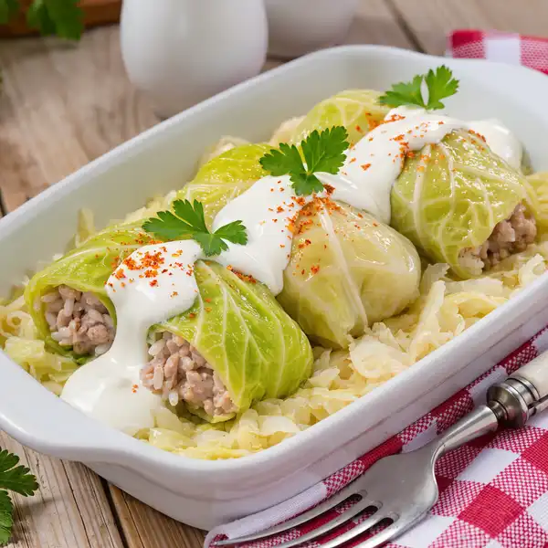 Szabolcsi töltött káposzta - Cabbage rolls stuffed with pork and rice, cooked with sauerkraut and served with sour cream; sample in traditional csárda restaurants.